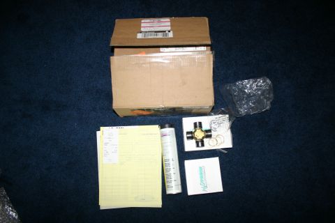 2003 Jeep TJ - A universal joint, paperwork, and shipping boxes are laid out on a dark blue carpeted surface.