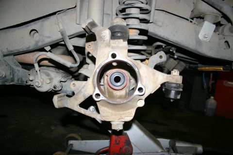 2003 Jeep TJ - Close-up of the front axle assembly of a 2003 Jeep TJ, showing the wheel hub and suspension linkage.
