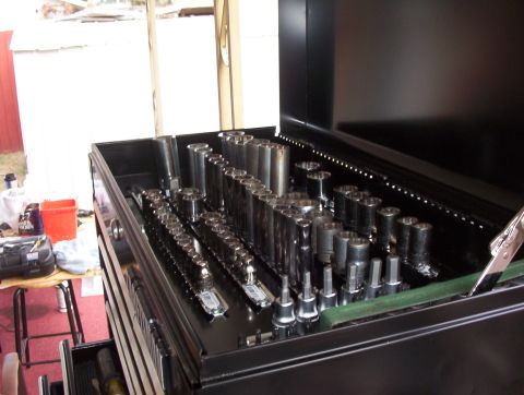 1993 Ford Bronco - A black toolbox is filled with an assortment of sockets and wrenches, organized neatly within its drawers.