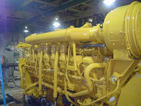 1966 International School Bus - A massive yellow engine is shown in a workshop environment with visible piping and machinery.
