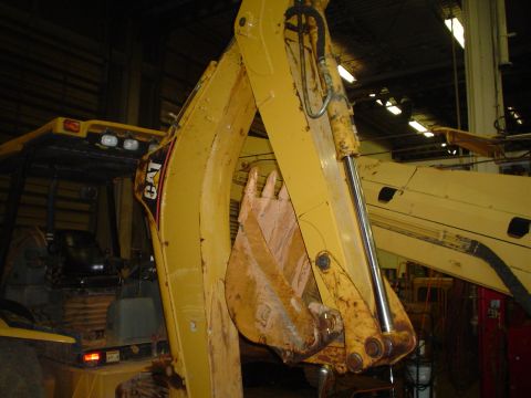 1966 International School Bus - Close-up view of a yellow excavator's arm and bucket, the CAT logo on the side.