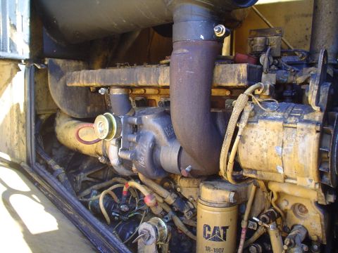 1966 International School Bus - Engine compartment detail showing a turbocharger, exhaust piping, and a CAT 1R-1807 oil filter.
