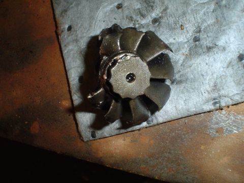 1966 International School Bus - A close-up view shows a damaged turbine wheel with bent blades resting on a textured surface.
