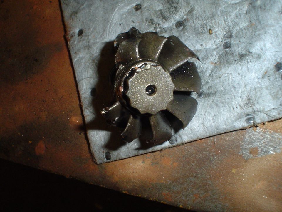 Damaged turbine wheel with bent blades on a metal surface