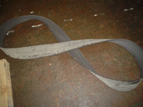 1966 International School Bus - A used serpentine belt is shown on a rough, stained concrete surface.