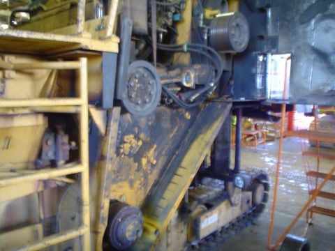 1966 International School Bus - Close-up view of yellow construction equipment, tracks and visible hydraulic hoses.