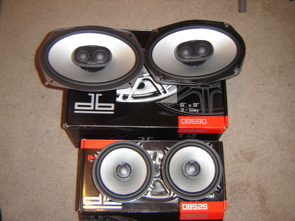 Two pairs of oval and round car speakers on boxes