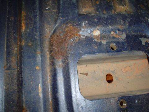 1984 Ford Bronco - Close-up of a rusted blue interior floor pan, showing signs of wear and tear.