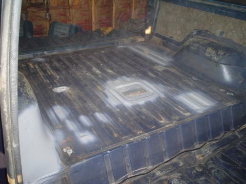 1984 Ford Bronco - The interior floor of a vehicle is shown, with some areas appearing to be prepped or sanded.