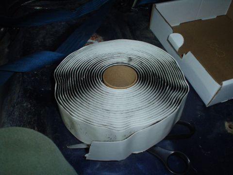 1984 Ford Bronco - Roll of butyl tape and scissors, likely for interior rebuild work.