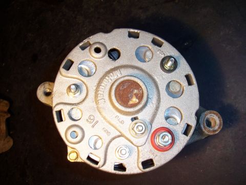 1983 Ford Bronco - Close-up of a metal alternator part with visible markings and hardware.