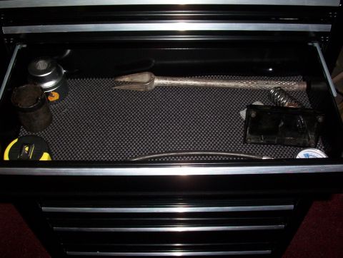 1993 Ford Bronco - A drawer in a toolbox contains various tools, including a tape measure and a pry bar.