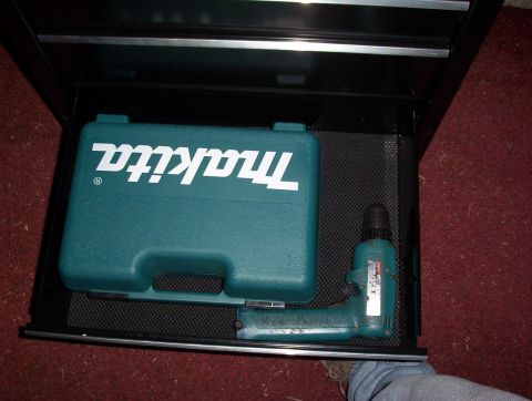 1993 Ford Bronco - A toolbox drawer contains a Makita tool case and a drill, resting on a black mat with red carpet nearby.