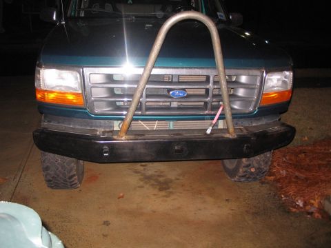 1996 Ford Bronco - Front view of a green 1996 Ford Bronco a custom bumper and a prominent brush guard.