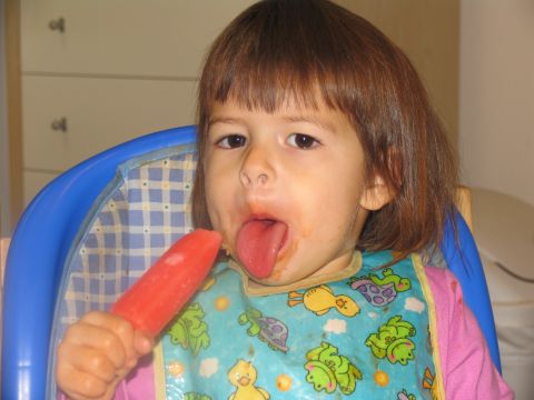 1984 Ford Bronco - A young child enjoys a red popsicle while wearing a bib with a turtle pattern.