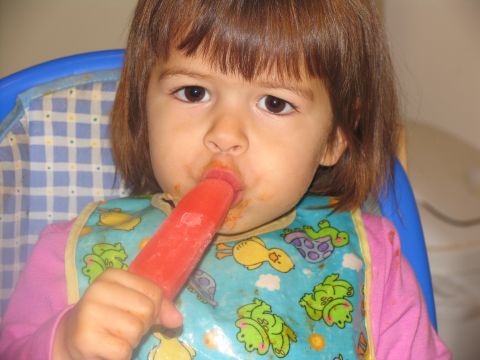 1984 Ford Bronco - A young child is seated in a high chair and enjoying a red popsicle.