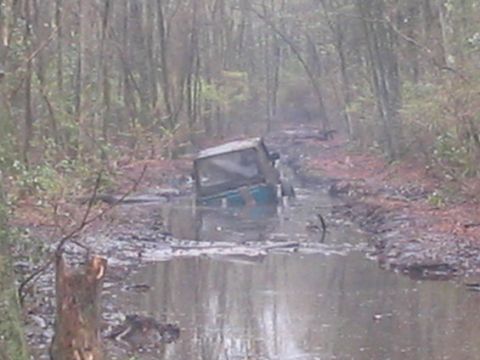 1987 Suzuki Samurai - This 1987 Suzuki Samurai is stuck deep in the mud on a wooded trail.