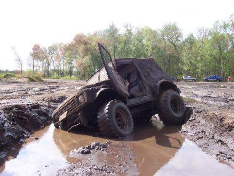 1987 Suzuki Samurai - This 1987 Suzuki Samurai is deeply stuck in a muddy ditch, its doors flung open.