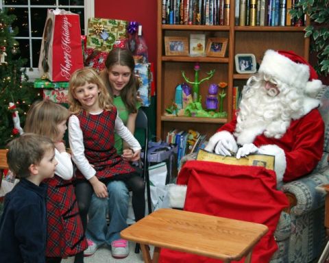 1991 Ford Bronco - Santa Claus reads a book to a group of children in a festive holiday setting with a Christmas tree and presents.