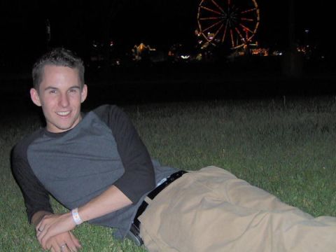 1996 Ford Probe - Man relaxes on grass with a Ferris wheel visible in the distance at night.