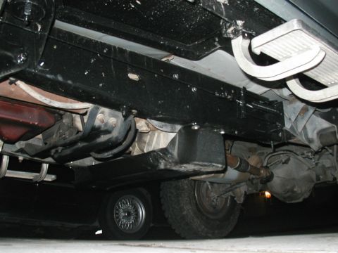 1989 Ford Bronco - The underside of a vehicle is shown, revealing its frame, exhaust system, and rear axle.