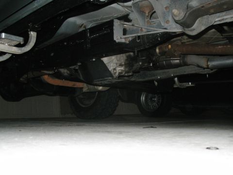 1989 Ford Bronco - The underside of a vehicle is visible, revealing its mechanical components and tires.