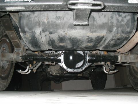 1989 Ford Bronco - Underside view of a vehicle's rear axle, differential, and fuel tank, showing the undercoating.