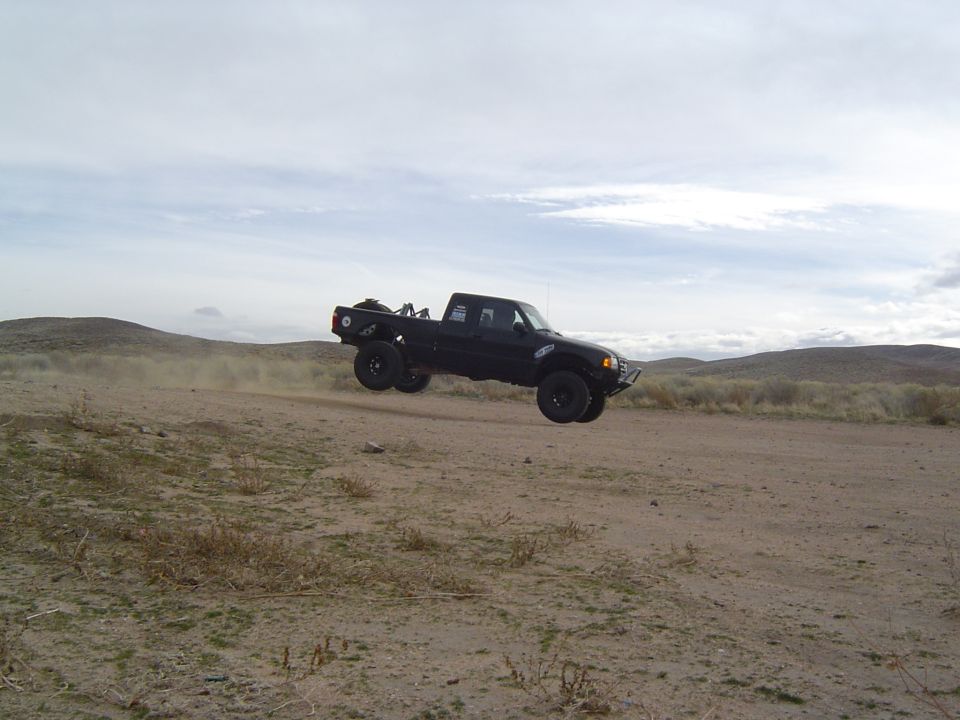 Black 1985 Ford Ranger mid-air jump, 3q-front view