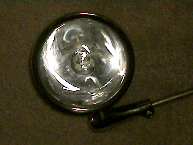 Headlight with chrome bezel and black mounting bracket