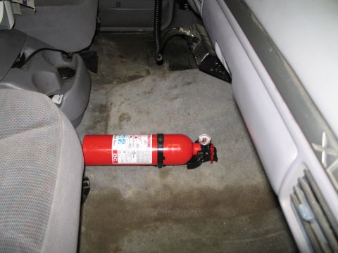 1995 Ford Bronco - A red fire extinguisher is visible on the floor of a vehicle's interior.