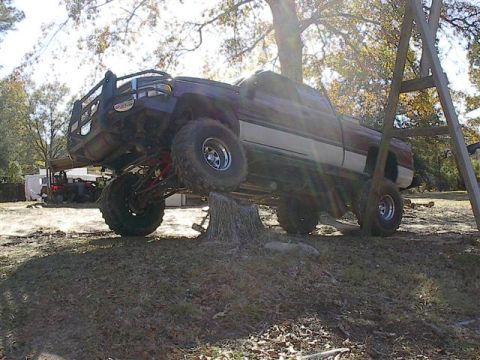 2001 Dodge 1500 - This modified 2001 Dodge 1500 pickup truck is precariously balanced on a tree stump, its lifted suspension.