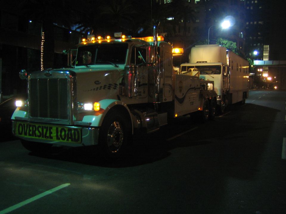 Tow truck with "OVERSIZE LOAD" sign on front bumper