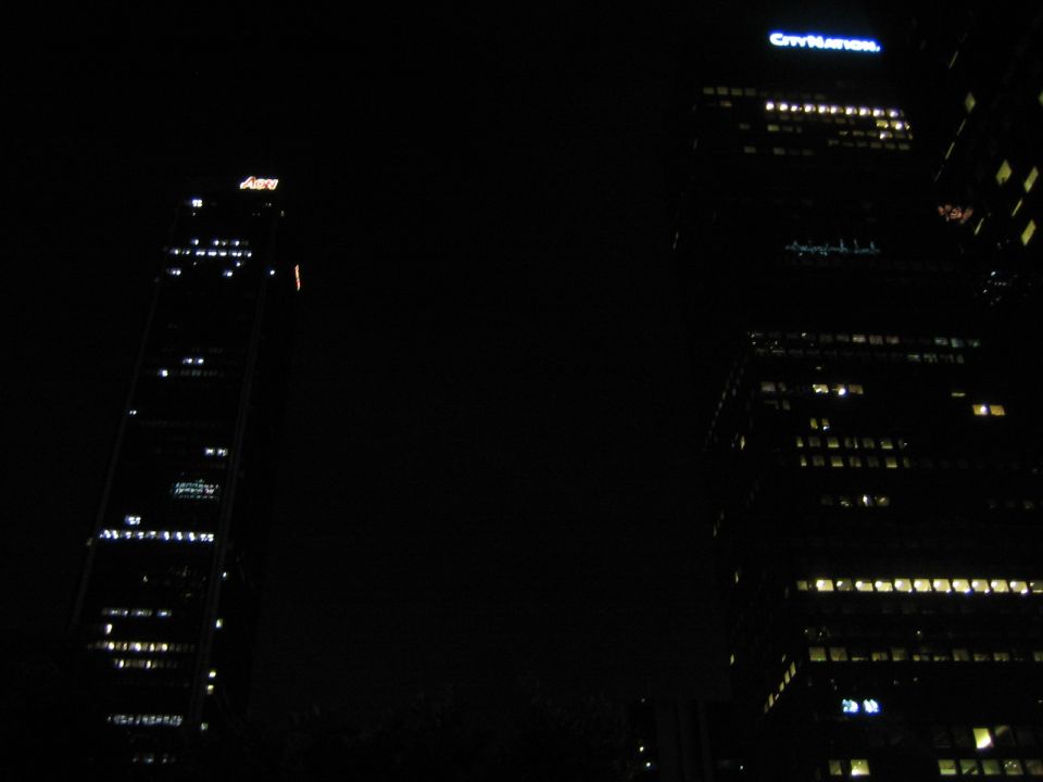 City buildings at night with illuminated windows and rooftop signs