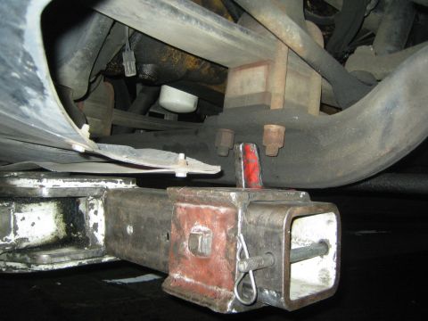 1968 Ford Mustang - Close-up view of a vehicle's undercarriage, focusing on the trailer hitch assembly and suspension.