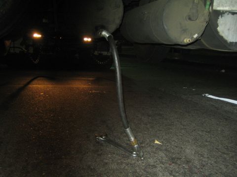 1968 Ford Mustang - The underside of a truck shows an air brake hose connected to a large tank, with lights visible in the background.