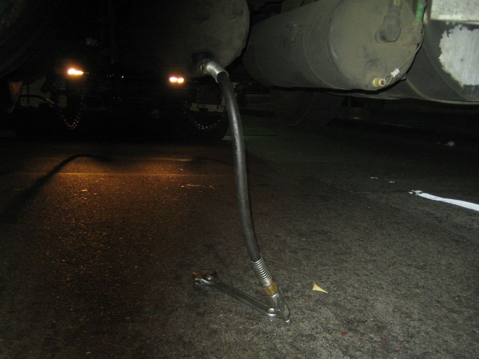 Close-up of a truck's air brake system with a hose connected to a tank