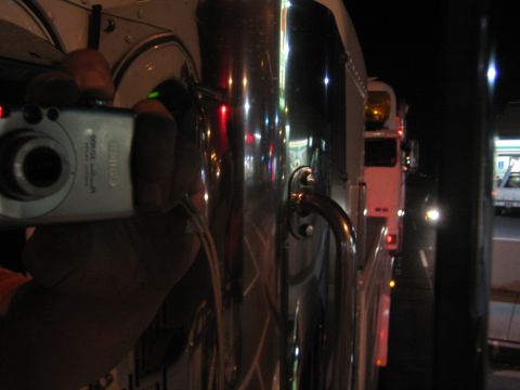1968 Ford Mustang - A person's hand holds a camera, reflecting in the chrome of a large truck at night.