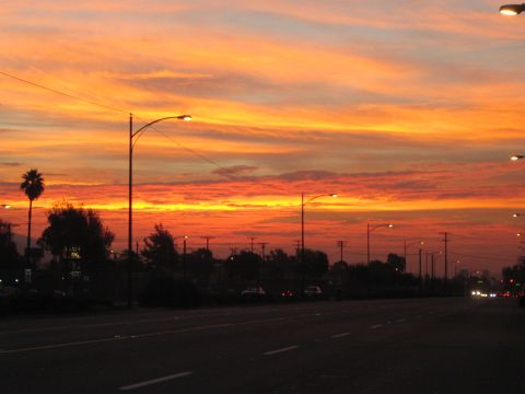 1968 Ford Mustang - The sky is ablaze with color during a sunset over a suburban roadside.