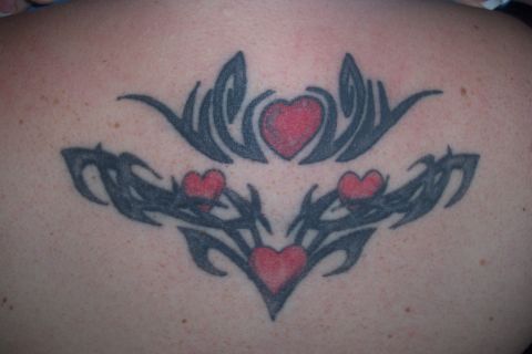 1987 Ford Bronco - A tattoo tribal patterns and red hearts is shown on a person's back.