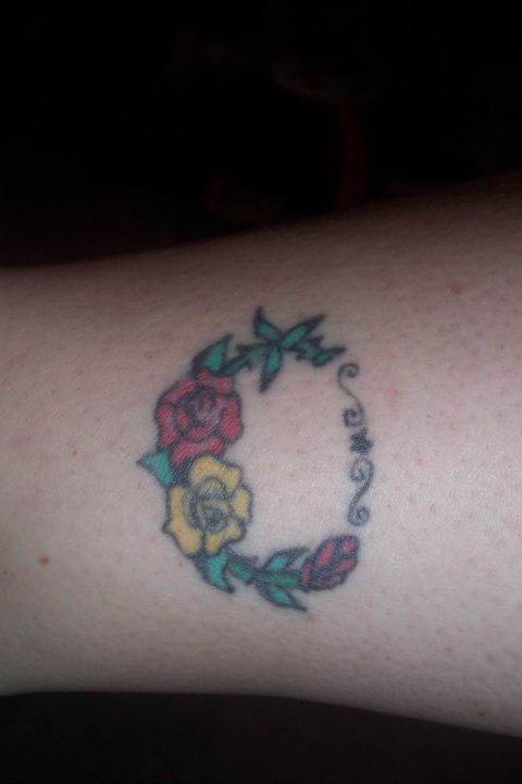 1987 Ford Bronco - A tattoo roses and vine-like swirls is visible on skin.
