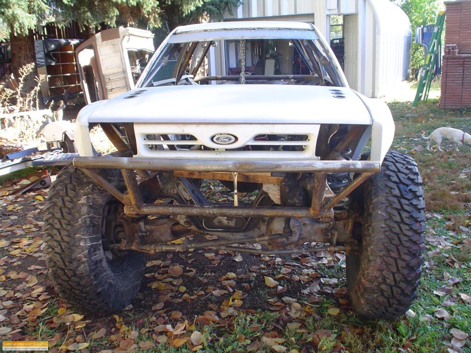 White off-road truck front view with custom bumper and large tires. Ford emblem visible on grille