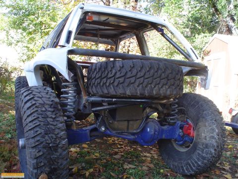 1991 Ford Bronco - Custom rear suspension and axle setup on a heavily modified SUV, large off-road tires.