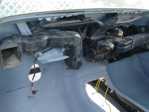 1979 Ford Bronco - The interior of a vehicle shows disassembled HVAC components and ductwork, with exposed wiring and unfinished surfaces.
