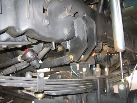 1994 Ford Bronco - Close-up view of the steering linkage and leaf springs, with a shock absorber visible.