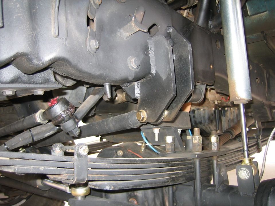 Steering linkage and leaf springs with a shock absorber