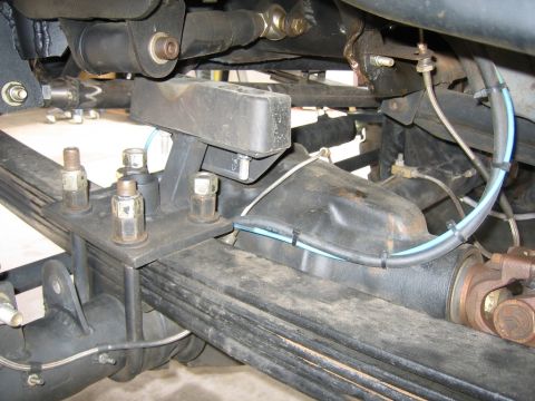 1994 Ford Bronco - Close-up view of vehicle's rear axle and suspension system, showing leaf springs and U-bolts.