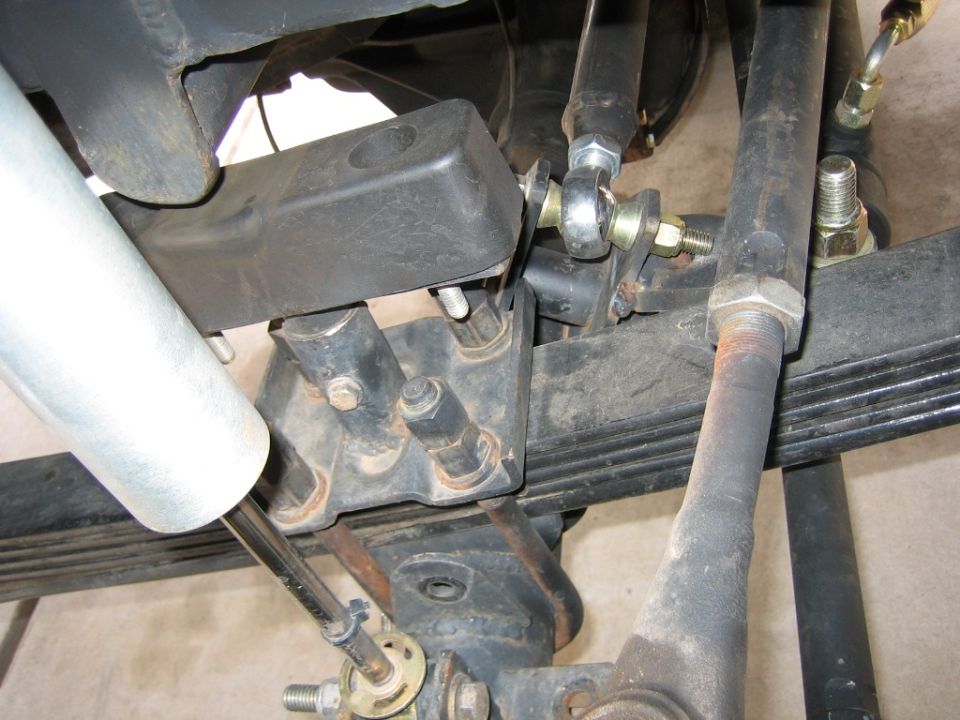 Close-up of vehicle suspension components, including a shock absorber and leaf springs
