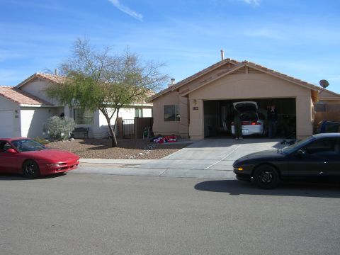 1996 Ford Probe - Two Ford Probes are visible in front of a suburban house with an open garage.