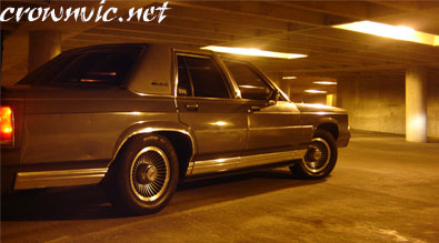 1988 Ford LTD Crown Victoria - Side view of a 1988 Ford Crown Victoria LTD parked in a dimly lit parking garage.