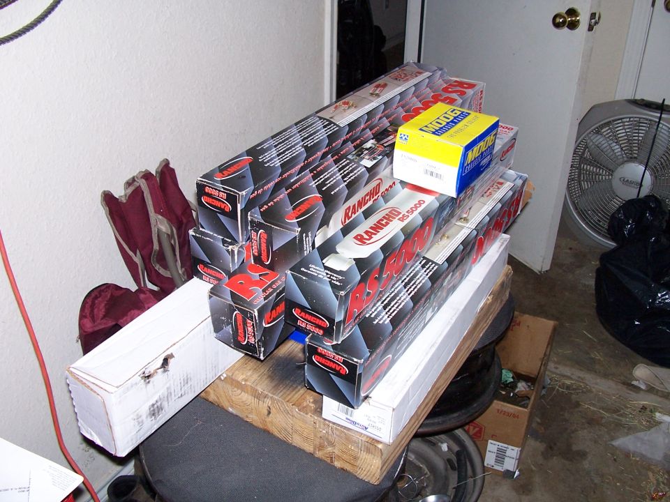 Boxes of Rancho RS5000 shocks and other parts stacked on a shelf